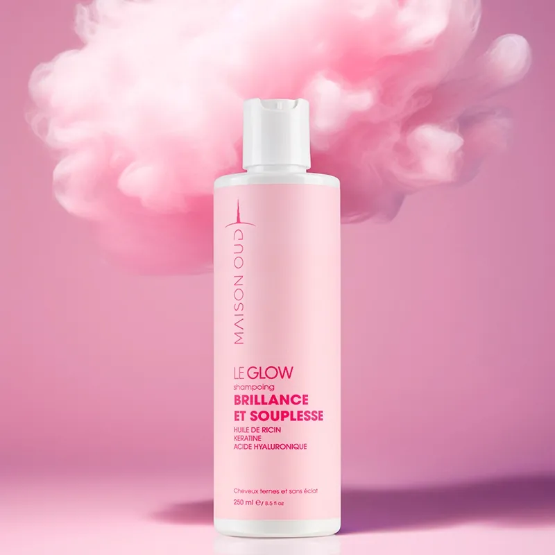 Photo publicitaire d'un shampoing rose devant un nuage rose